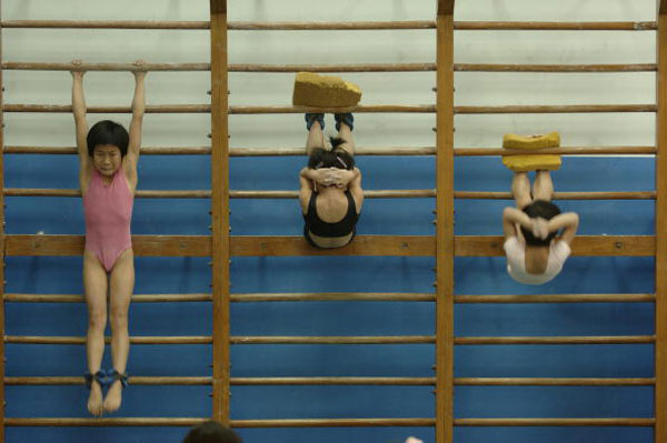 children-hang-from-a-bar-during-training-september-23,-2005-in-beijing,-china-_1417678325