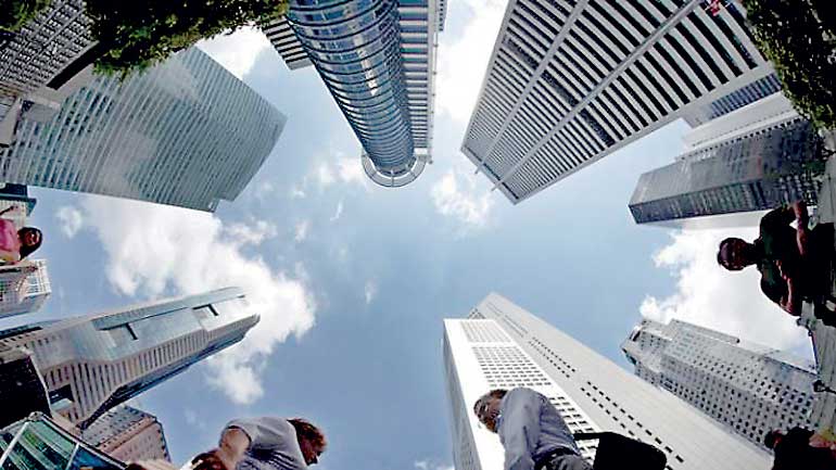 File photo of people walking past office buildings at the central business district in Singapore