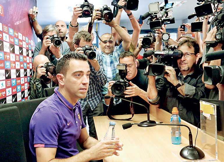 Barcelona's soccer player Hernandez is surrounded by photographers before a news conference after a training session at the Barcelona training grounds Ciutat Esportiva Joan Gamper in Sant Joan Despi