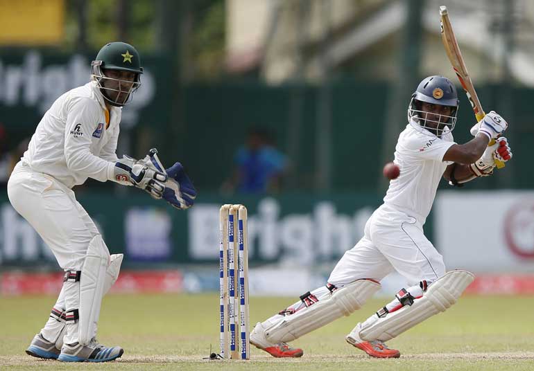 Sri Lanka's Silva plays a shot next to Pakistan's Ahmed during the second day of their second test cricket match in Colombo
