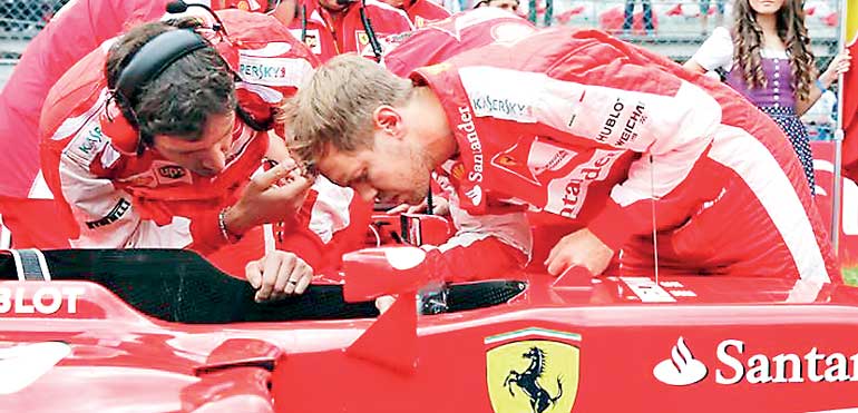 Ferrari driver Vettel of Germany looks into his car after Austrian F1 Grand Prix in Spielberg