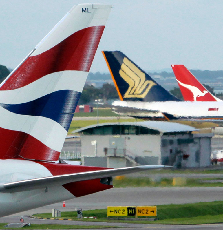 The tail wings of British Airways, Singapore Airlines and Qantas Aiways planes are pictured at Singapore Changi Airport