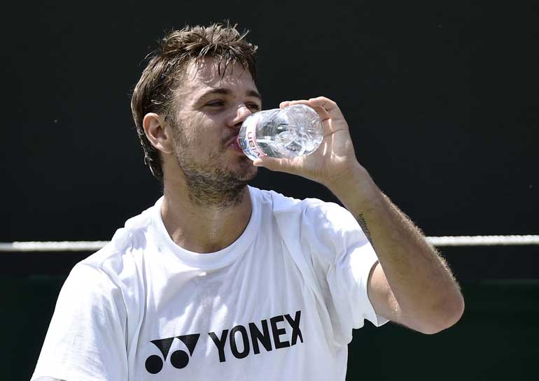 Switzerland's Wawrinka takes a drink during a practice session at Wimbledon in London