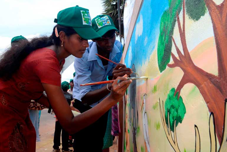 Children painting the walls in Mannar