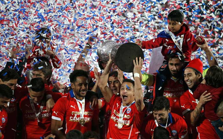 Chile's Alexis Sanchez holds the Copa America trophy as he celebrates with his teammates following their victory over Argentina in their Copa America 2015 final soccer match at the National Stadium in Santiago