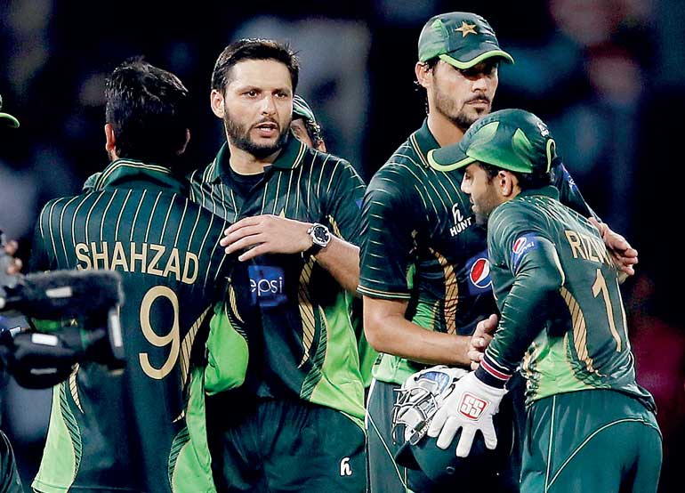 Pakistan's captain Afridi congratulates his teammates after they won their first Twenty 20 cricket match against Sri Lanka in Colombo
