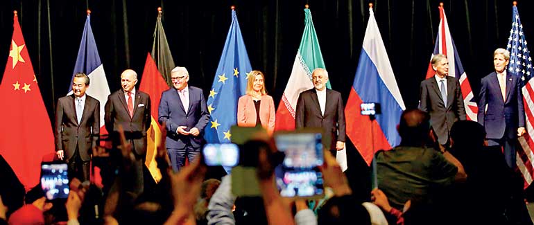 Ministers and officials pose for a family picture after the last plenary session at the United Nations building in Vienna