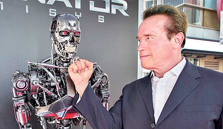 Cast member Schwarzenegger poses by a Terminator replica at the premiere of "Terminator Genisys" in Hollywood