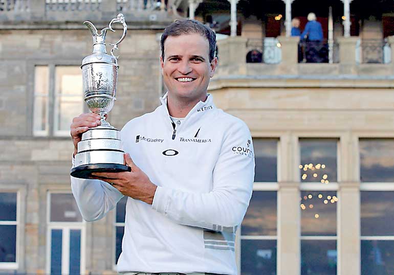 Johnson of the U.S. celebrates as he holds the Claret Jug after winning the British Open golf championship on the Old Course in St. Andrews, Scotland