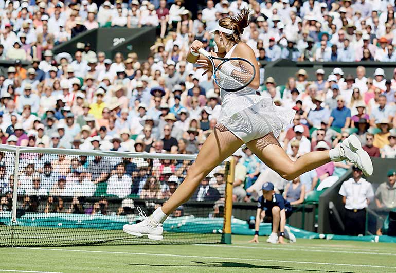 Garbine Muguruza of Spain hits a shot during her match against Agnieszka Radwanska of Poland at the Wimbledon Tennis Championships in London