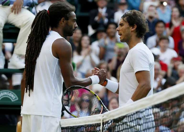 Dustin Brown of Germany shakes hands with Rafael Nadal of Spain after winning their match at the Wimbledon Tennis Championships in London