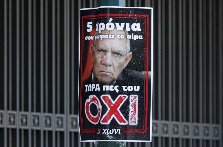 A referendum campaign poster depicting German Finance Minister Schaeuble is seen in front of the National Bank building in Athens