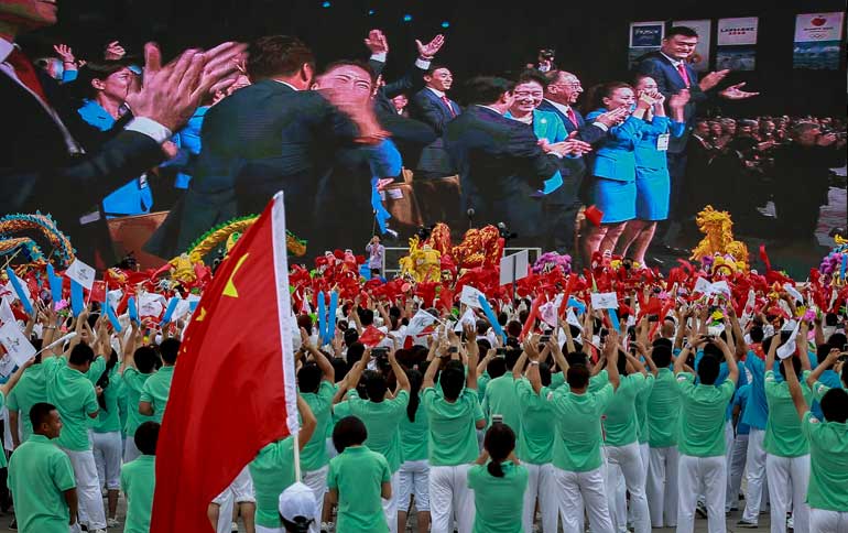 People cheer as they watch on a screen the IOC announcing Beijing as the winner city for the 2022 Winter Olympics bid, outside the Birds' Nest, also known as the National Stadium, in Beijing