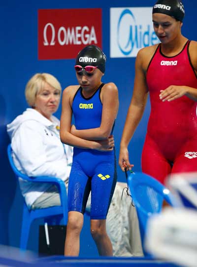 Tareq of Bahrain and Zeqiri of Kosovo leave pool side after women's 50 m butterfly at Aquatics World Championships in Kazan