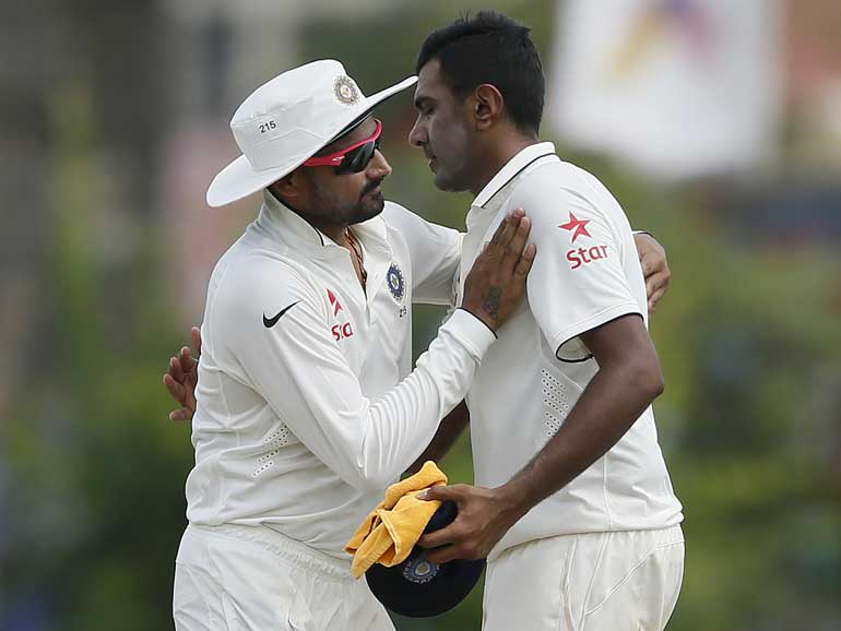 India's Ashwin is congratulated by his teammate Harbhajan Singh after taking six wickets in first innings during the first day of their first test cricket match against Sri Lanka in Galle