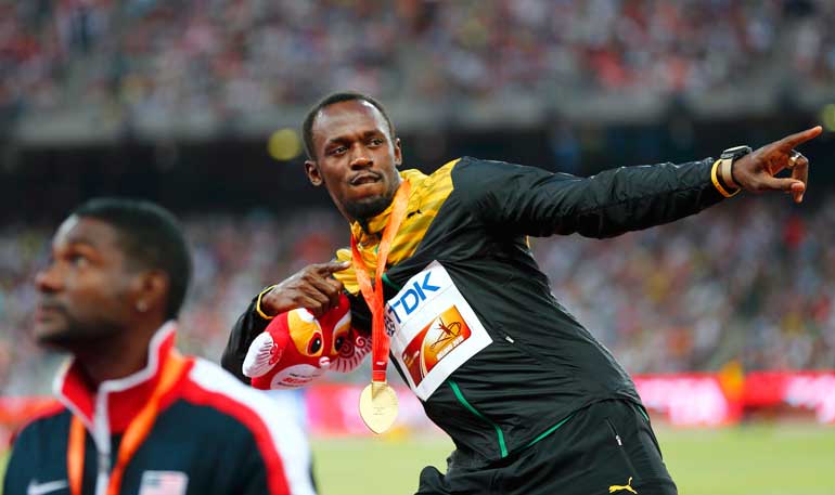 Usain Bolt of Jamaica, gold medal, reacts as he poses on the podium next to Justin Gatlin of the US, silver medal, after the men's 200 metres event during the 15th IAAF World Championships at the National Stadium in Beijing