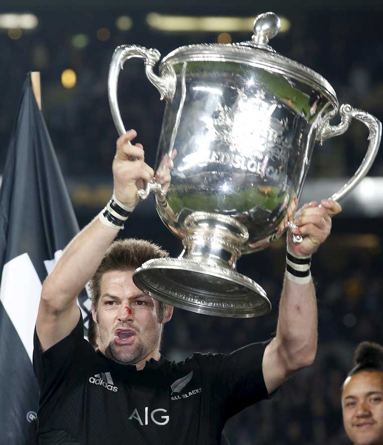 New Zealand's All Black's captain Richie McCaw hoists the trophy as he celebrates winning against Australia after their Bledisloe Cup rugby match at Eden Park in Auckland