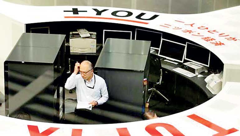 TSE employee looks at monitors at the Tokyo Stock Exchange in Tokyo