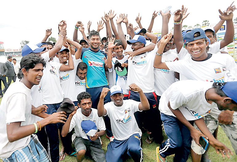 Sri Lanka's Sangakkara poses for photographs with ground workers during his retirement ceremony after India won their second test cricket match against Sri Lanka in Colombo