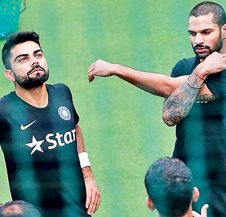 India's cricket captain Kohli stretches next to his teammate Dhawan during a practice session ahead of their test cricket series against Sri Lanka, in Colombo