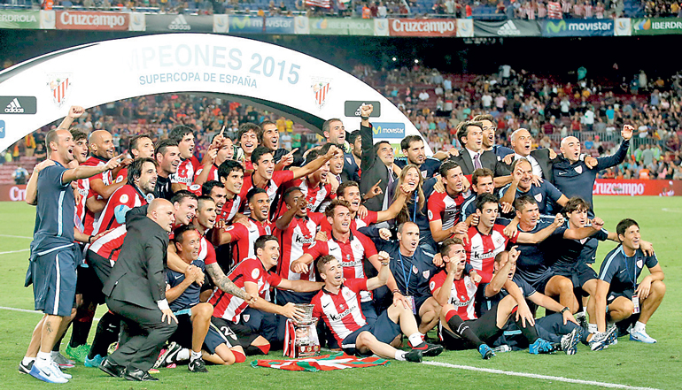 Athletic Bilbao's players pose with the Spanish Super Cup trophy after defeating Barcelona at Camp Nou stadium in Barcelona