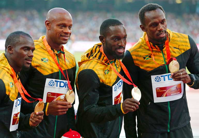 Usain Bolt of Jamaica and teammates Nesta Carter, Asafa Powell, Nickel Ashmeade, gold medallists, pose on the podium after the men's 4 x 100 metres relay event during the 15th IAAF World Championships at the National Stadium in Beijing