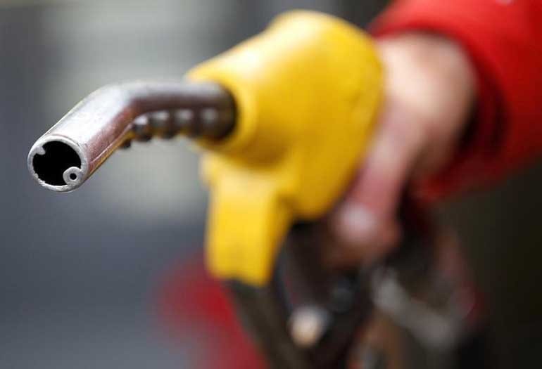 An attendant prepares to refuel a car at a petrol station in Rome