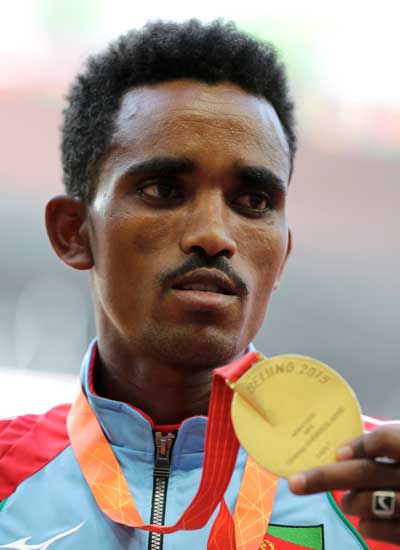 Ghebreslassie of Eritrea presents his gold medal after winning the men's marathon race during the 15th IAAF World Championships at the National Stadium in Beijing