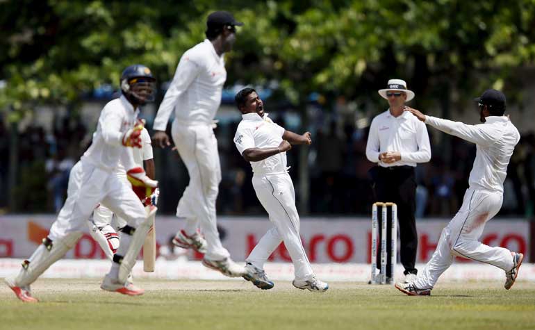 Sri Lanka's Herath celebrates with his teammates after taking the wicket of India's Rahane on the fourth day of their first test cricket match in Galle