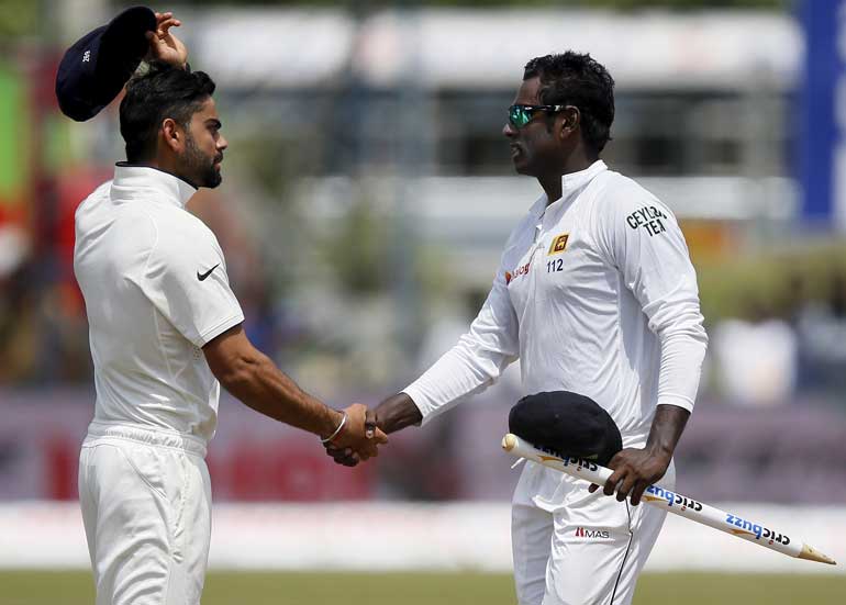 Sri Lanka's captain Mathews shakes hands with India's captain Kohli after Sri Lanka won their first test cricket match against India in Galle