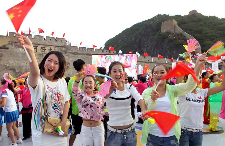 People wave Chinese national flags as they cheer after the IOC announced Beijing as the winner city for the 2022 winter Olympics bid, at the foot of the Great Wall, in Zhangjiakou