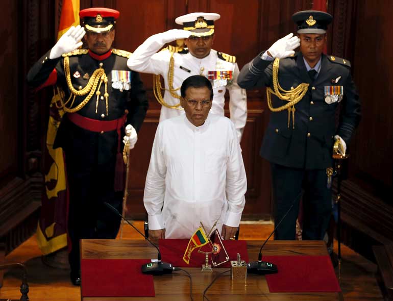 Sri Lanka's President Sirisena stands for the national anthem during a ceremony to swear in Wickremesinghe, leader of the United National Party, as Sri Lanka's new prime minister in Colombo