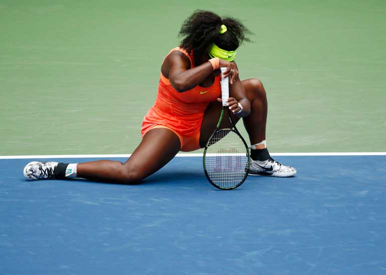 Williams of the U.S. gets up slowly from the court in the third set against Vinci of Italy during their women's singles semi-final match at the U.S. Open Championships tennis tournament in New York