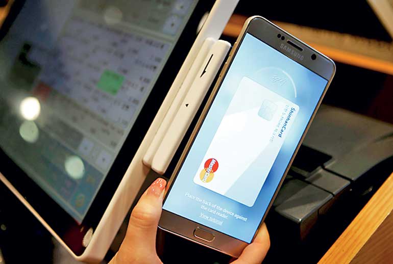 An employee demonstrates a Samsung Pay, Samsung's new mobile payment system at a shop in Seoul