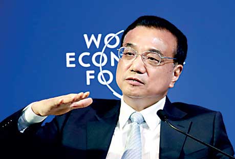 China's Premier Li gestures as he answers a question during a meeting with foreign company executives at the WEF in Dalian