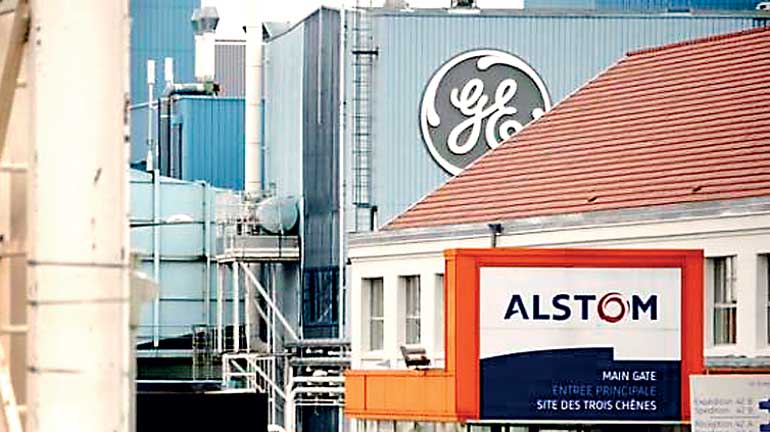 The logos of French power and transport engineering company Alstom and US conglomerate General Electric are pictured at the site of the companies in Belfort
