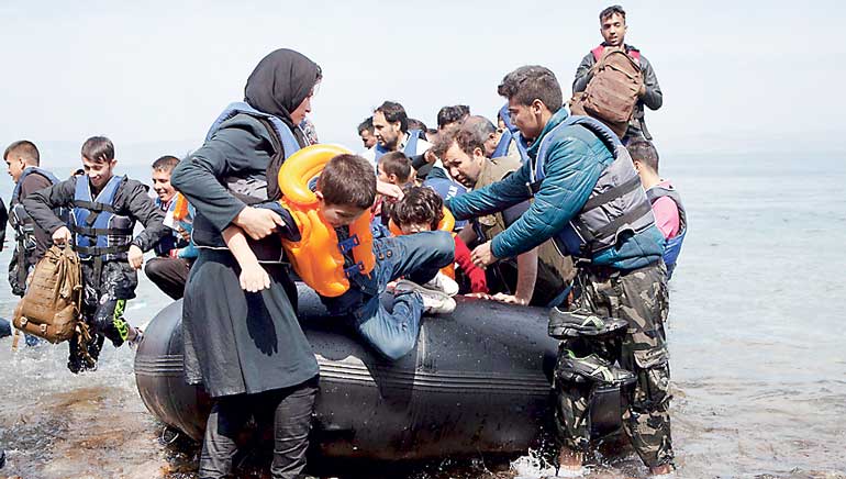 Afghan refugees arrive on a dinghy on the Greek island of Lesbos