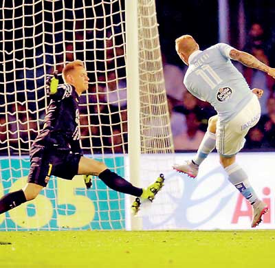 Celta Vigo's Guidetti scores a goal at Barcelona's goalkeeper Stegen during their Spanish first division soccer match at Balaidos stadium in Vigo