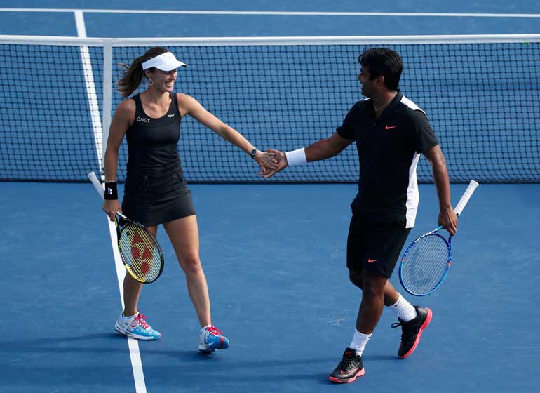 Hingis of Switzerland celebrates a point with mixed doubles partner Paes of India during their finals match against Mattek-Sands and Querrey of the U.S. at the U.S. Open Championships tennis tournament in New York
