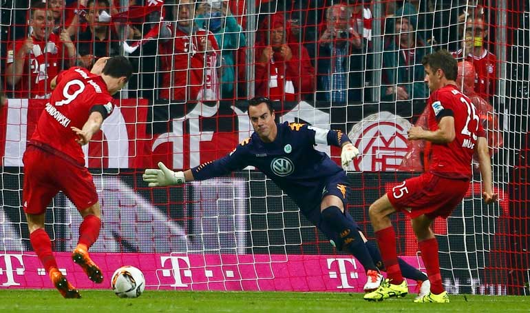 Bayern Munich's Lewandowski (L) scores a goal past Wolfsburg's goalkeeper Benaglio during their German first division Bundesliga soccer match in Munich