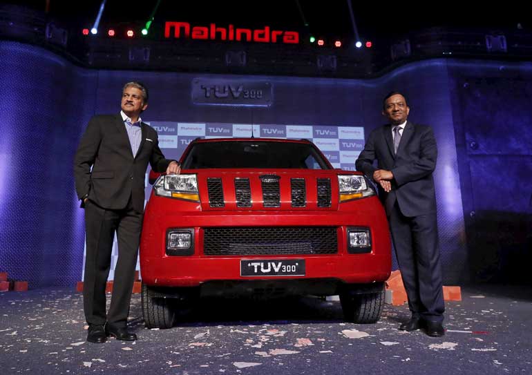 Mahindra and Goenka of Mahindra & Mahindra pose with their newly launched TUV300 vehicle in Chakan