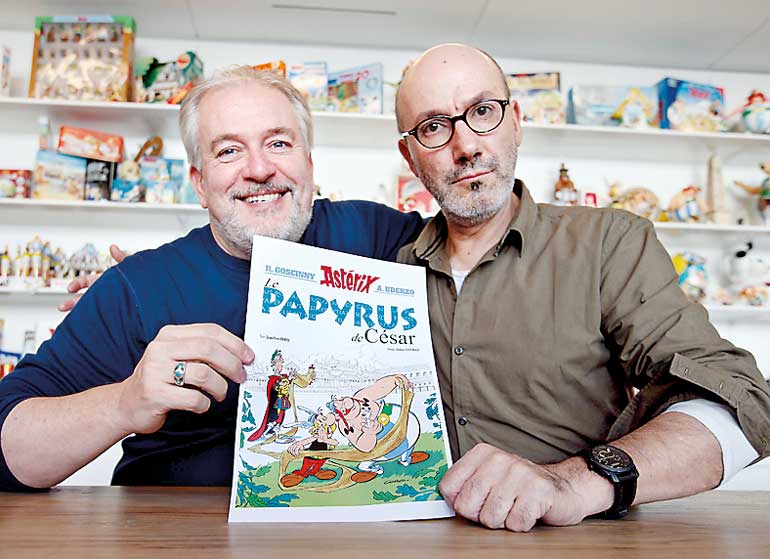 Author Jean-Yves Ferri and illustrator Didier Conrad pose with the front page of their new comic book "Le Papyrus de Cesar" (Asterix and the Missing Scroll) in Vanves, Southern Paris