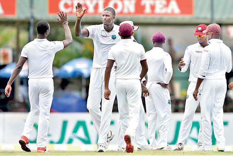 West Indies' captain Holder celebrates with his teammates after taking the wicket of Sri Lanka's captain Mathews during the first day of their second test cricket match in Colombo