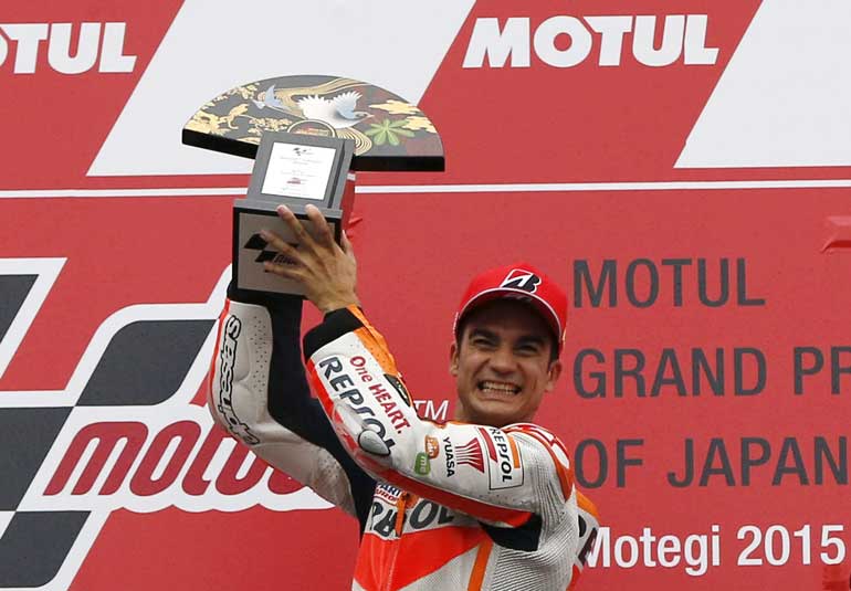 Honda MotoGP rider Pedrosa of Spain raises his trophy as he celebrates on the podium after winning the Japanese Grand Prix at the Twin Ring Motegi circuit in Motegi