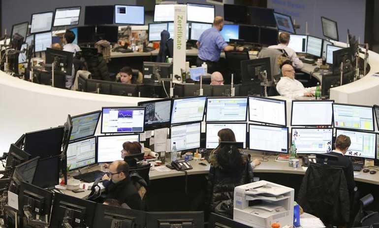 Traders work at their screens at the stock exchange in Frankfurt