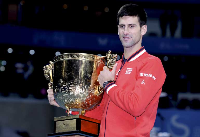 Djokovic of Serbia poses with his trophy during the award ceremony after winning the men's singles final match against Nadal of Spain at the China Open Tennis Tournament in Beijing