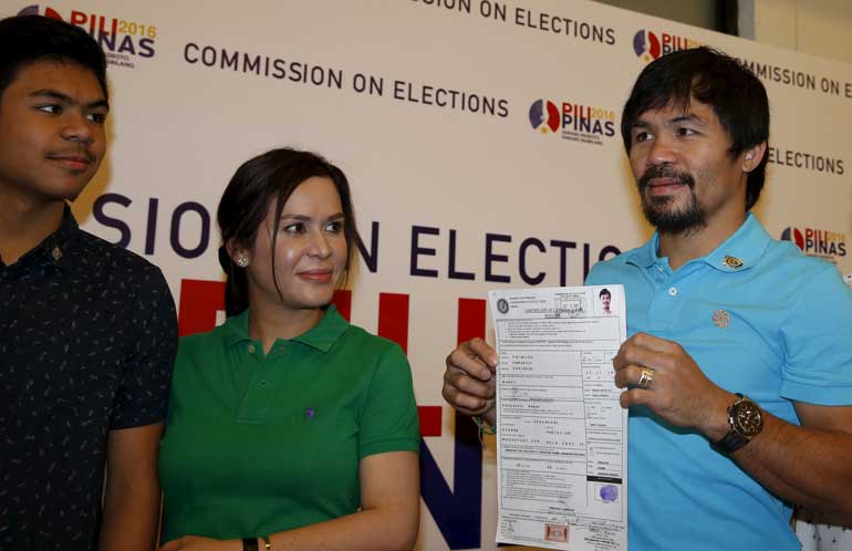 Filipino boxer Manny Pacquiao shows to the media his Certificate of Candidacy for Senator in the May 2016 national elections, at the Commission on Elections in Manila