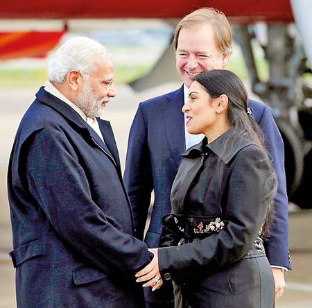 India's Prime Minister Narendra Modi is greeted by Britain's Minister of State for the Foreign and Commonwealth Office, Hugo Swire and MP Priti Patel after arriving at Heathrow Airport for a three day official visit, in London