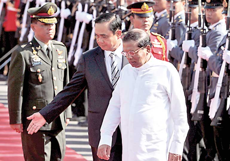 Sri Lanka's President Maithripala Sirisena and Thailand's Prime Minister Prayuth Chan-ocha review the honour guard during a welcoming ceremony at Government House in Bangkok