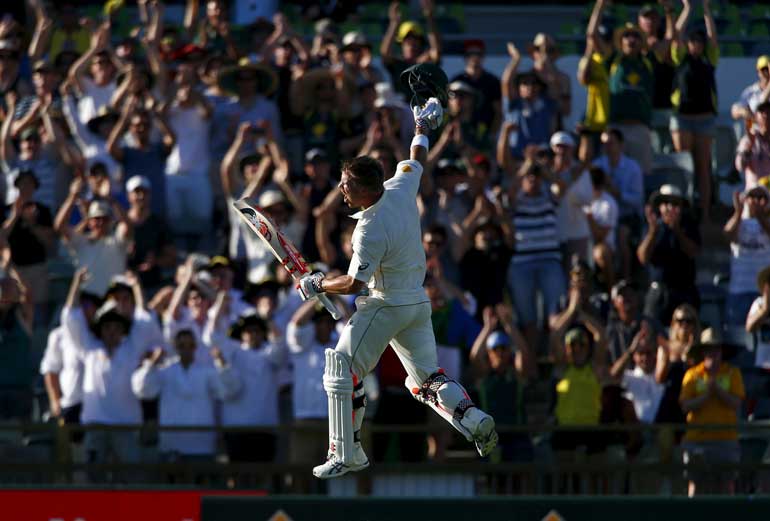 Australia's David Warner celebrates reaching his double-century during the first day of the second cricket test match against New Zealand at the WACA ground in Perth, Western Australia